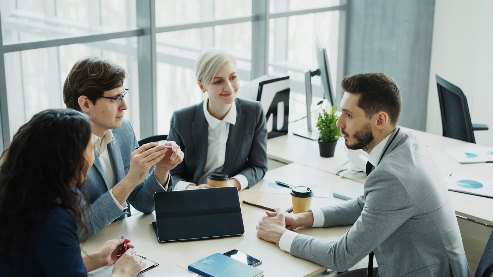 Un equipo de cuatro personas revisa información en una tableta.